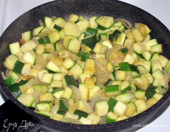 Цукини нарежьте кубиками в 1 см и добавьте к луку, жарьте, помешивая, 5-7 минут.
