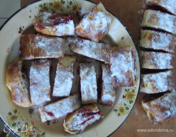 Раскатать тонко, завернуть начинку - малину свежую. Немного присыпать малину манкой, чтобы сильно не вытек сок при выпечке. Смазать яйцом взбитым. Поставим в очень горячую духовку на 20 минут.
Готовые штрудели посыпать сахаром. Разрезать горячими.