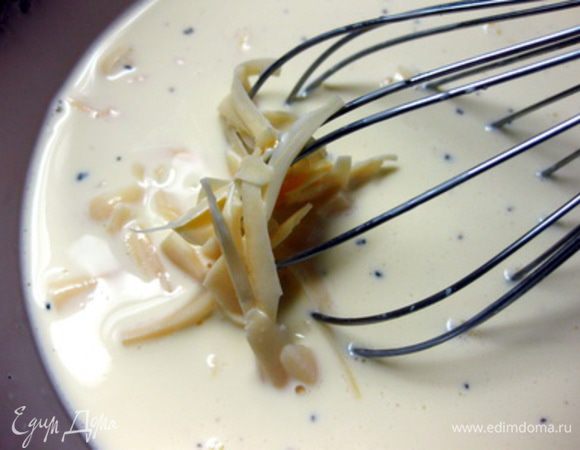 Сыр натрите на крупной терке. Взбейте яйца со сливками, добавьте соль и перец. Положите половину сыра, перемешайте.