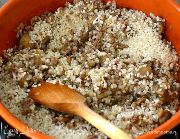 Выложить рис и как следует перемешать с мясом, грибами и луком. Позволить рису напитаться всеми "соками". 