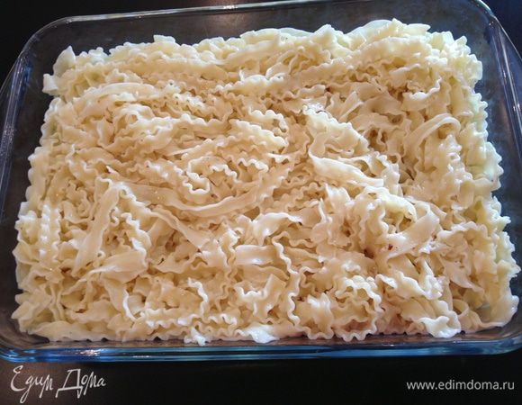 Отвариваем лапшу. Сливаем бульон, в котором она варилась, но не весь! Половину бульона отложите, он еще понадобится. 
В лапшу, уже без бульона, кидаем сливочное масло и выключаем плиту, но не убираем с нее кастрюлю с макаронами, чтобы масло растаяло. И перемешиваем. Затем  перекладываем лапшу в форму для духовки  