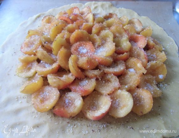 Посыпать молотым миндалем, отступив от края 2 см. Сверху выложить половинки абрикос, посыпать сахаром и крахмалом.