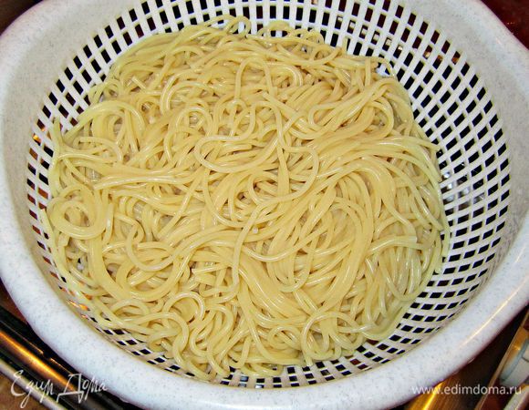 Готовые спагетти отбросьте на дуршлаг.