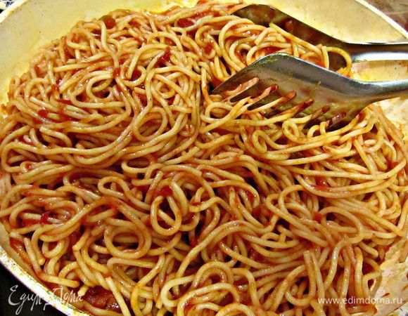 Спагетти смешайте с томатным соусом, добавьте половину натёртого сыра  и прогрейте на огне 1 мин.