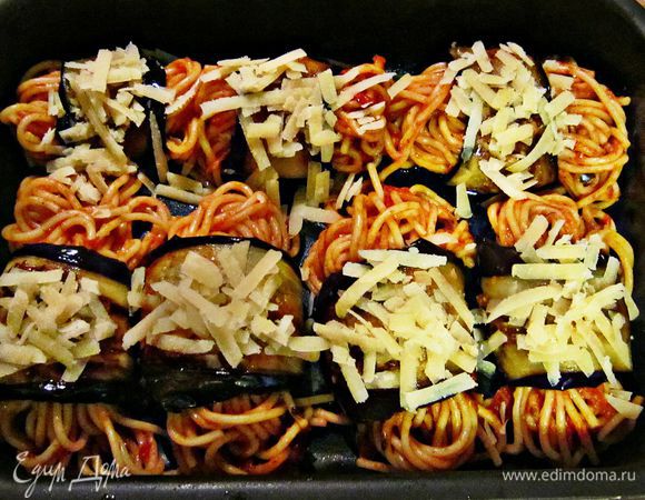 На середину каждого ломтика баклажана выложите немного спагетти и скатайте рулетики. Выложите рулетики на смазанный оливковым маслом противень и сверху посыпьте оставшимся сыром.
Запекайте 10 мин при 200г.
 