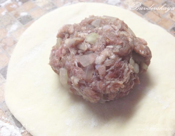 4. Обминаем подошедшее тесто и начинаем формовать беляши. От большого куска отделяем небольшие кусочки примерно 45-50 г (размером с мандарин), Присыпанной мукой рабочую поверхность и раскатываем наши шарики в лепешки толщиной примерно 0,3-0,5 см. На середину каждой лепешки кладем фарш.