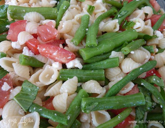 Добавить макароны, фасоль, половину феты и зелени, перемешать. Подавать теплым. Посыпать оставшимся сыром  и травами.