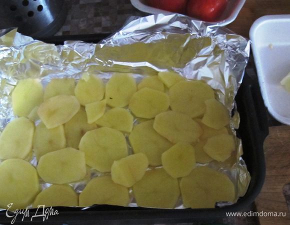 На дно наливаем немного соуса и выкладываем слой картошки.