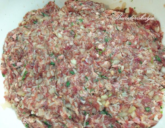 Лук, рис, зелень, зиру добавить в фарш. Хорошо перемешать, посолить, поперчить и добавить холодную воду. Хорошенько вымесить (отбить) фарш.