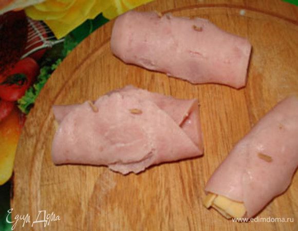 Сыр завернуть в ветчину. Закрепить деревянными шпажками, если длинные тогда отломайте половину.