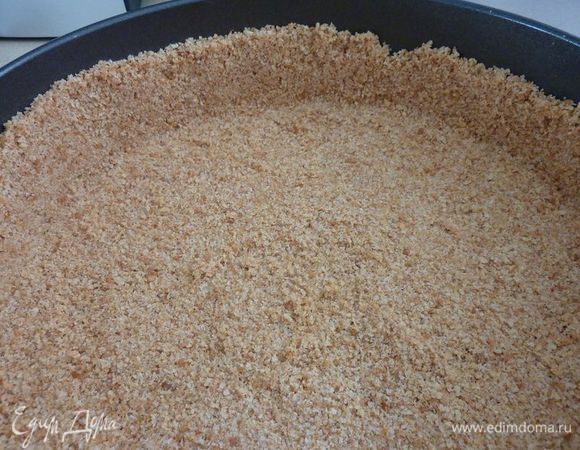 Утромбовать крошки равномерно на дно формы ( диамитр форма 24 см )  и на края формируя стаканом бортик премерно 2 см .