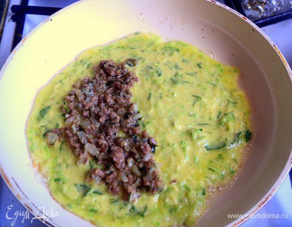 Нагреть сковородку, смазать маслом, налить тесто, чтобы получился не толстый блинчик.
Сразу же, пока блин не схватился, выложить 1 ст.ложку  фарша на одну сторону блина, оставив свободными края.
