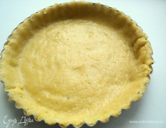 Выложить тесто в форму Ф-20см, излишки теста обрезать при помощи скалки. Положить сверху бумагу для выпечки и насыпать горох или фасоль. Печь при температуре 180 градусов 15 минут  до легкого зарумянивания. 