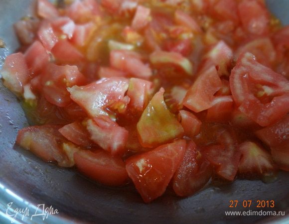 На разогретой сковороде с оливковым маслом обжарить измельченный чеснок, добавить очищенные от кожицы и порезанные томаты, потушить на среднем огне минуты 2-3.