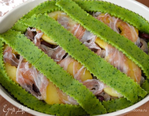 Тесто достать из холодильника, раскатать в пласт толщиной приблизительно 4-5 мм. И нарезать полосками шириной 2 см. Расположить одну полоску теста по периметру формы, вокруг. А остальные полоски выложить по диагонали сверху запеканки. 