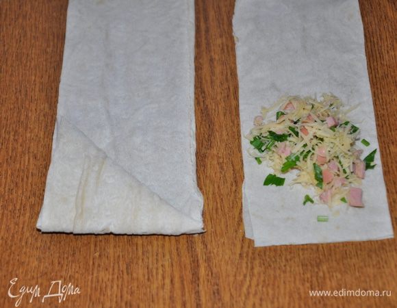 Выложить начинку на край полоски и свернуть уголком 3-4 раза, чтобы вся начинка оказалась скрыта, отрезать лишнее. Таким образом свернуть  остальные пирожки.