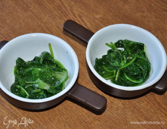 Шпинат припустить в сковороде на оливковом масле до мягкости.
В порционные жаропрочные формочки разложить шпинат.

