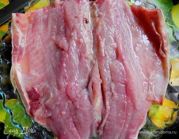 Сначала подготовим карпа. Потрошим, избавляем от чешуи.
Отрезаем голову и хвост. Затем прорезаем его со стороны брюшка, но не до конца, чтобы получилась "бабочка". Освобождаем от крупных костей, вырезая их очень аккуратно.
Затем замаринуем карпа в лимонном соке примерно на полчаса, пока готовим "подстилку" из лука. Можно и не мариновать, мне захотелось цитрусовой ноты.