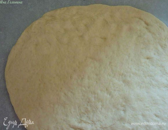 Рабочую поверхности слегка посыпать мукой . Замесить тесто снова и раскатать его в круглую форму и уложить на посыпанную мукой бумагу для выпечки . Перенести на продвинь , и с помощью пальцев сформировать своего рода рамку вокруг пиццы , небольшой бортик .