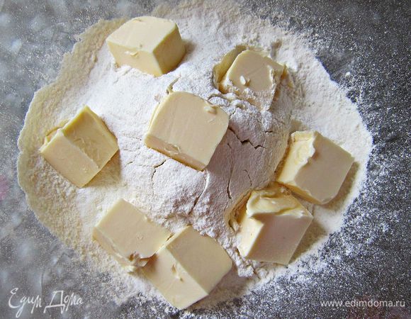 Муку просеять, добавить разрыхлитель. Затем порубить сливочное масло и растереть с мукой руками до образования мелкой крошки.
