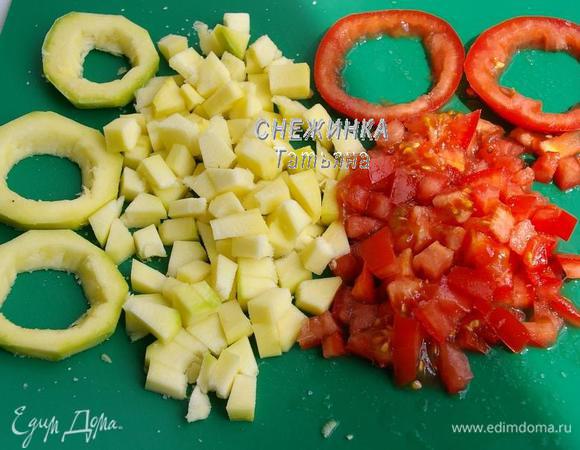 Подготавливаем овощи. Моем их. Затем от цукини отрезаем 3 кружочка, от помидора – 2 кружочка. Остальные цукини и помидор нарезаем небольшим кубиком. Серединку овощей вырезаем и также измельчаем, чтобы остались колечки. Присаливаем всё.