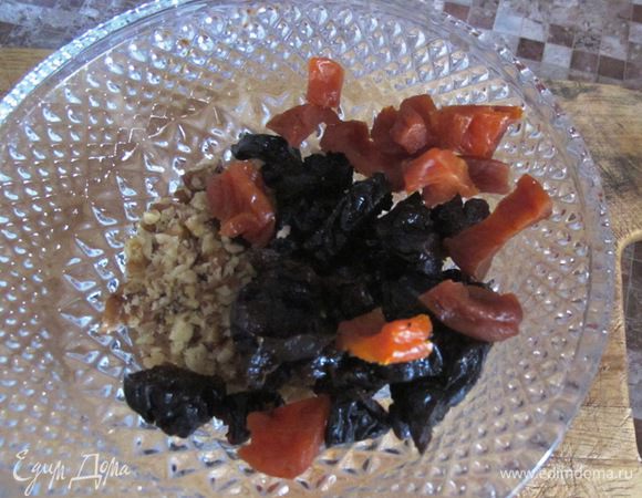 Нарежьте курагу и чернослив, раздробите орехи.