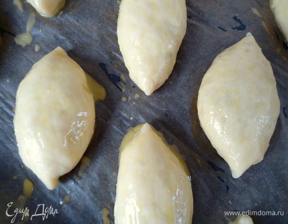 переворачиваем швом вниз 
и укладываем на противень смазанный маслом или на пекарскую бумагу.
Поверхность смазать желтком, разбавленным  двумя столовыми ложками молока. Дать время на расстойку.
