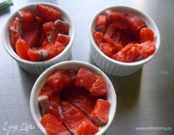 Формочки смазываем маслом и выкладываем в них кусочки лосося (у меня получилось 3 шт). Оставляем место в центре. Солим, перчим.