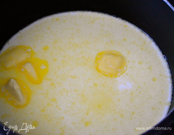 В кастрюльку с тяжелым дном налить молоко и положить 50 г масла, добавить щепотку соли и поставить на огонь, довести до кипения.