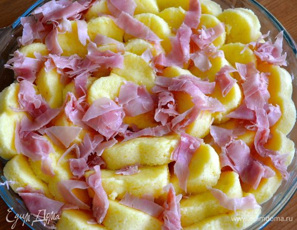 Выложить кусочки ветчины поверх манных клецок. 