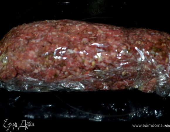 Выложим  мясную смесь на пищевую пленку с сухарями, сформируем в рулет и свернем.