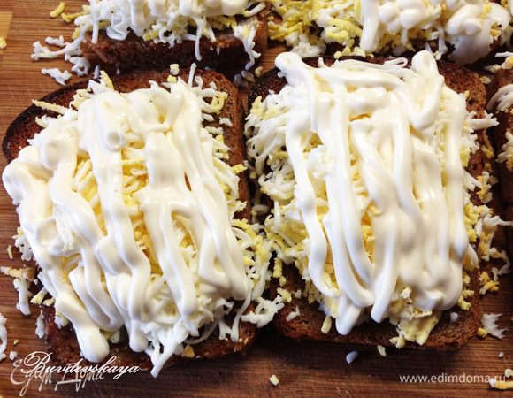 У пакетика майонеза отрезать маленький уголок, чтобы получилась тоненькая сеточка из майонеза на каждом бутерброде поверх натертого яйца.