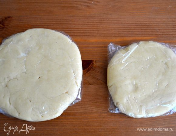 Тесто поделить руками на две неравные части; одна часть должна быть чуть больше другой. БОльшая часть теста станет основанием пая, более маленькая - его "крышкой". Из каждой части сформировать шар, немного его расплющить, формируя лепешку, обернуть каждую в пленку и убрать в холодильник минимум на 1 час (можно и на всю ночь!).  