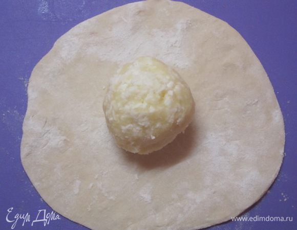 Разделить тесто  на кусочки. Каждый кусочек раскатать в небольшую лепешку. В центр лепешки выложить сырно-картофельный шарик. Края теста собрать сверху.