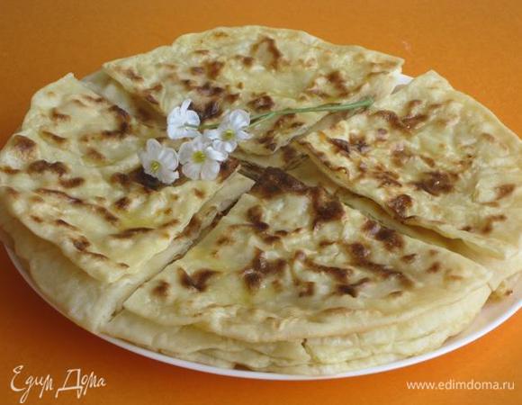 Испеченные хычины смазать сливочным маслом. Складывать друг  на друга. Разрезать на 4 части.