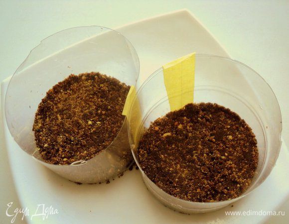 Установить на блюдо формочки, наполнить смесью печенья и шоколада, уплотнить и поставить в холодильник застывать. Формочки я сделала из пластмассовой бутылки из под воды. С одной стороны формочки надрезаны и склеены скотчем, чтобы потом  их легче было  снять.