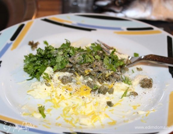 Каперсы и зелень мелко порубить. В тарелке размять вилкой масло и добавить каперсы, зелень, цедру и сок лимона.