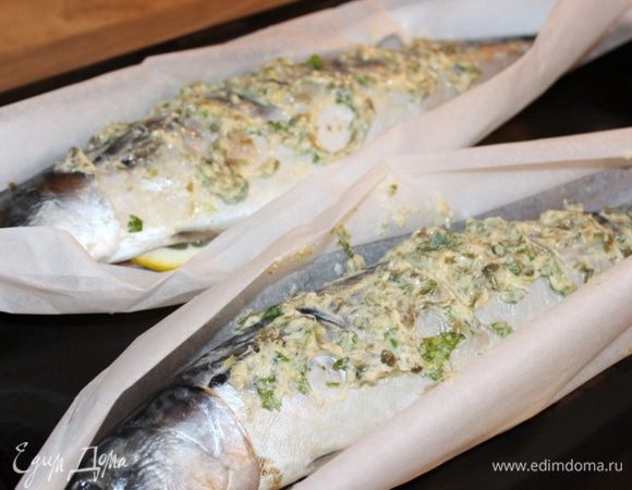 Листы пергамента, размером чуть больше рыбы, смазать небольшим количеством масляной смеси. Уложить сверху скумбрию. Смазать рыбу сверху и в брюшке оставшимся ароматным маслом. В брюшко уложить 2 полудольки лимона. Концы пергамента соединить и скрутить, образуя "лодочку" вокруг рыбы. Выпекать скумбрию около 20 минут при 180*С. Если хочется более румяной корочки, то можно на минуту поставить готовую рыбу под гриль.