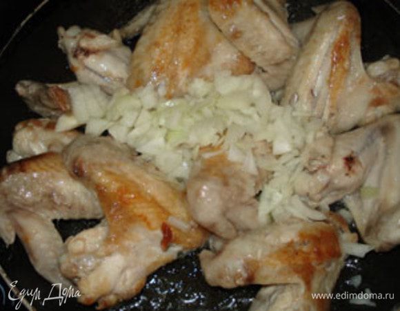 Крылья обжарить до золотистого цвета на масле. Добавить нарезанный лук.