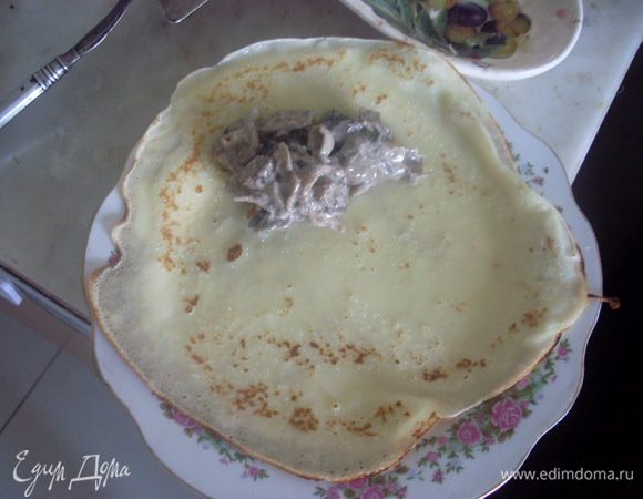 На готовый блинчик сложить ложку начинки и свернуть конвертиком.