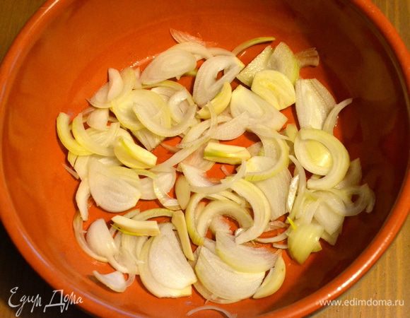 На дно сковороды с высокими бортами (у меня керамическая форма) налить немного масла. Выложить слоем лук с чесноком. Это должна быть сковорода, которую можно поставить на "открытый" огонь, и в духовку одновременно! 