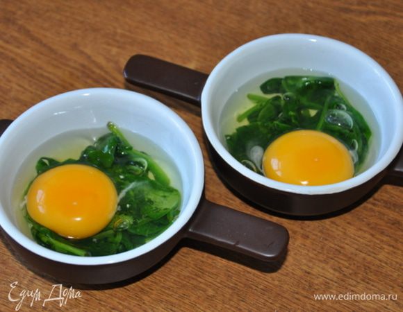 Сверху на шпинат разбить яйцо - аккуратно, чтобы желток остался целым, посолить.
