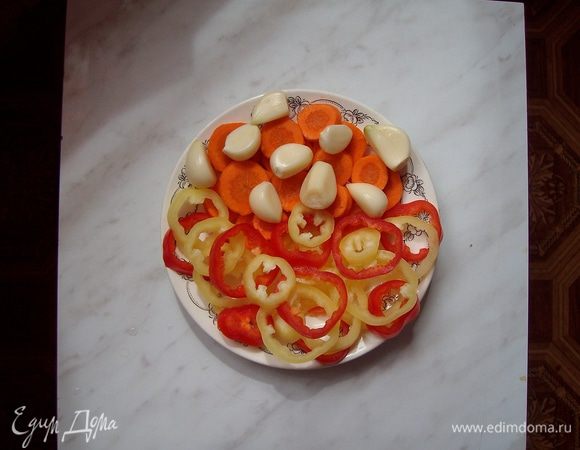 Нарезаем болгарский перец и морковь кружочками, чистим зубчики чеснока и корень хрена. Половинку корня хрена можно не нарезать, но мы нарезаем тонкими пластинками