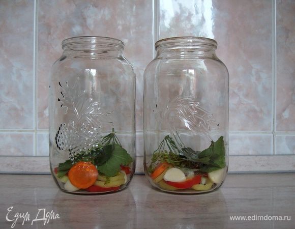 На дно банки укладываем болгарский перец, морковь, зубчики чеснока, хрен, листья смородины и вишни, лавровый лист, перец душистый горошком, зонтики укропа.
