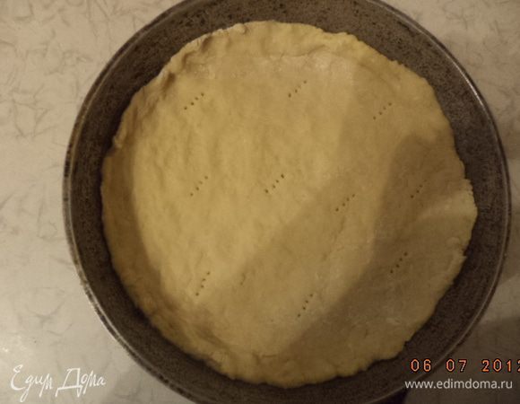 Форму для выпечки смазать маслом. Тесто разделить на 2 части: большую и меньшую. Большую часть теста раскатать и выложить в форму, сформировав бортики. Накрыть тесто пергаментом, сверху высыпать горох, выпекать при температуре 180 градусов 15 минут.