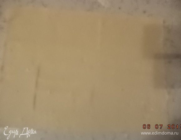 Слоёное тесто тонко раскатать в два одинаковых прямоугольных пласта.
Твёрдый сыр натереть на крупной тёрке.