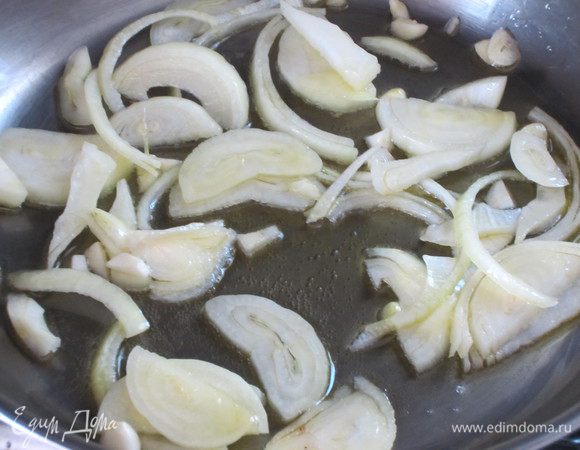 В глубокой сковороде разогреть оливковое масло, добавить лук, чеснок и пассеровать на слабом огне несколько минут.