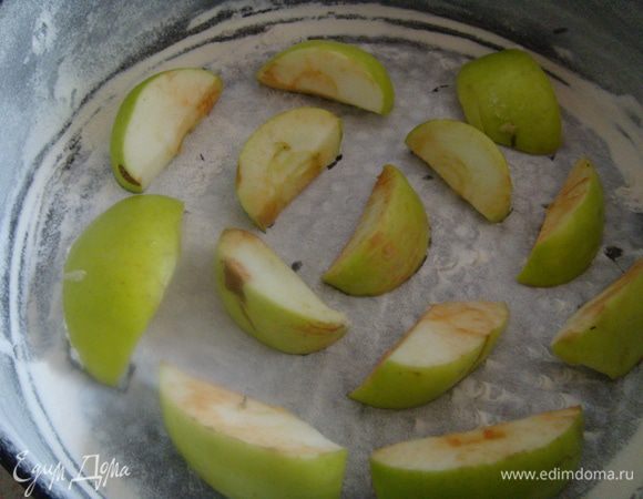 Заранее приготовить форму. Смазать раст. маслом, обсыпать мукой, выложить на дно часть яблок