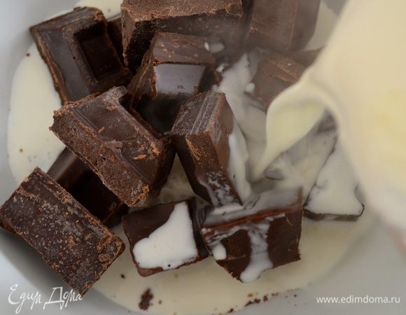 Для трюфеля кусочки шоколада положить в жаропрочную миску. Поставить на средний огонь сливки (2/3 ст.). Как только сливки закипят, залить ими шоколад и дать постоять пару минут. 