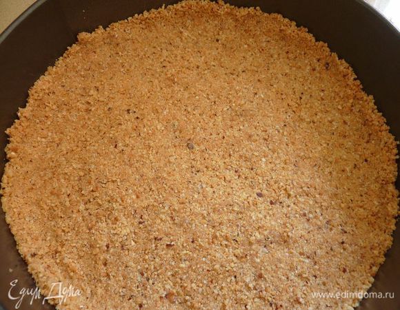 Пока стынет шоколад готовим основу: Смешать измельченный печенье, орехи и растопленное сливочное масло. Равномерно распределить по форме с боками и положить в морозильник или холодильник.
